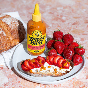 Sweet toast with fresh strawberries, cottage cheese, and a drizzle of Yellowbird Strawberry Ginger Hot Sauce and honey on crispy sourdough.