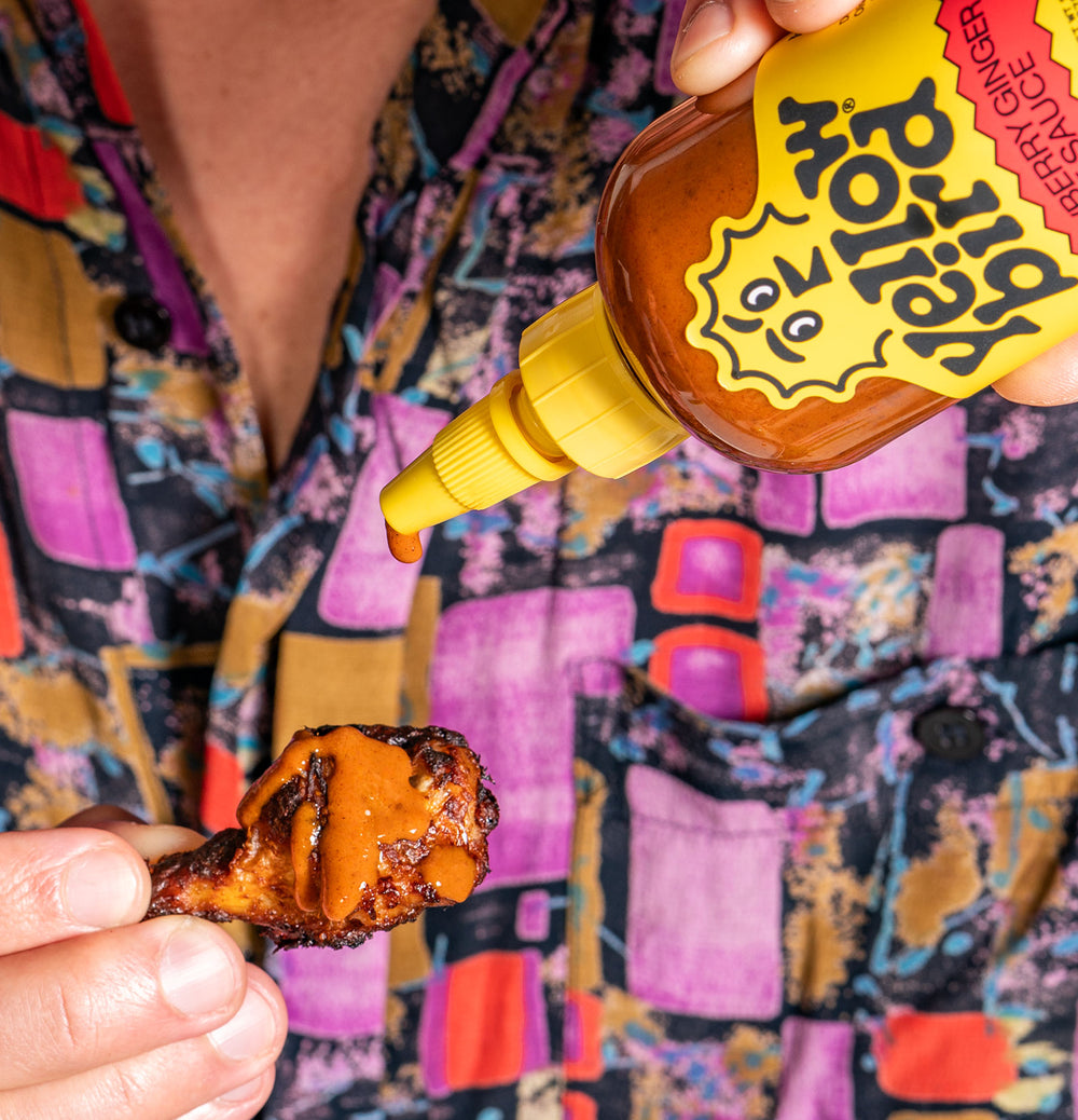 Yellowbird Small Batch Strawberry Ginger Hot Sauce drizzled onto a crispy air-fried chicken wing