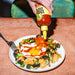 Yellowbird Organic Sriracha Hot Sauce on fried rice, broccoli, and sunny side up eggs