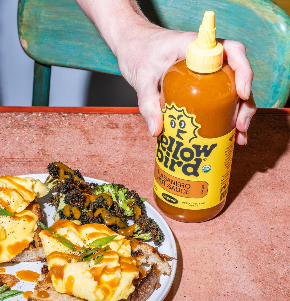 Yellowbird Organic Habanero Hot Sauce 19.6 oz. bottles drizzled onto scrambled egg toast